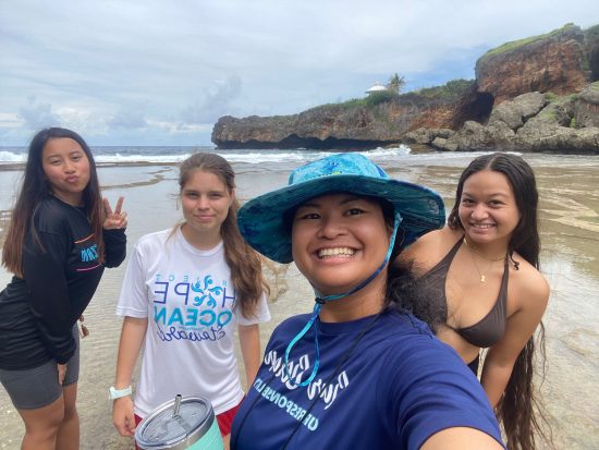 Four people in the picture with the background of the Jeffrey's Beach rocky shoreline and ocean